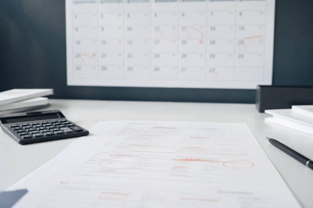 Calendrier annuel et procès-verbal flou avec une calculatrice sur un bureau