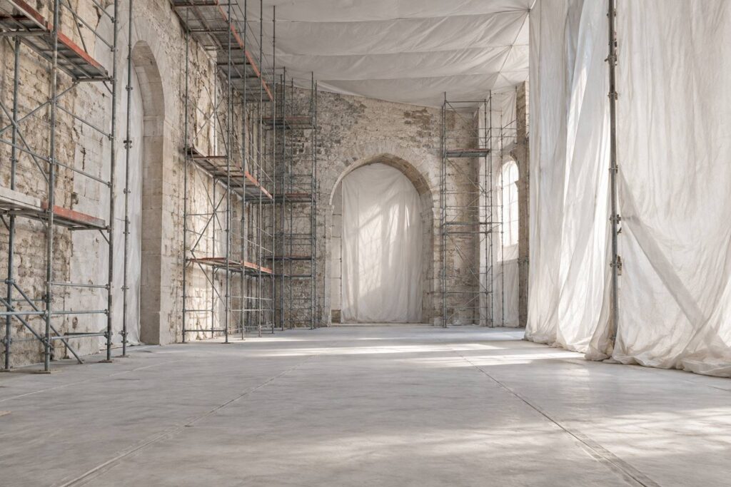 Chantier de renovation couvert avec echafaudage et mur en pierre